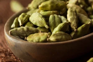 Vainas y semillas de cardamomo, representando el uso tradicional del cardamomo en la digestión y el bienestar corporal.
